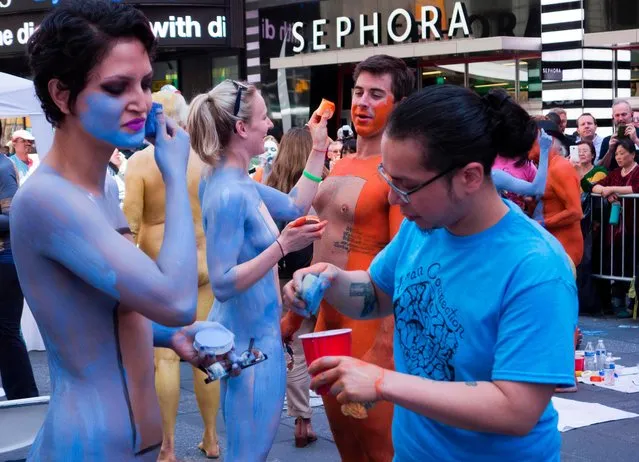 Models get their bodies painted in Times Square while being watched by the public June 9, 2017 in New York. The models displayed personal messages as a way to express how they feel about themselves and their bodies. (Photo by Don Emmert/AFP Photo)