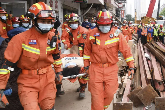 In this photo released by Xinhua News Agency, rescuers evacuate a woman pulled alive from a collapsed building in Changsha, central China's Hunan Province, May 1, 2022. The woman was rescued Sunday from the rubble of a building in central China more than 50 hours after it collapsed, leaving dozens trapped or missing, state media said. (Photo by Shen Hong/Xinhua via AP Photo)
