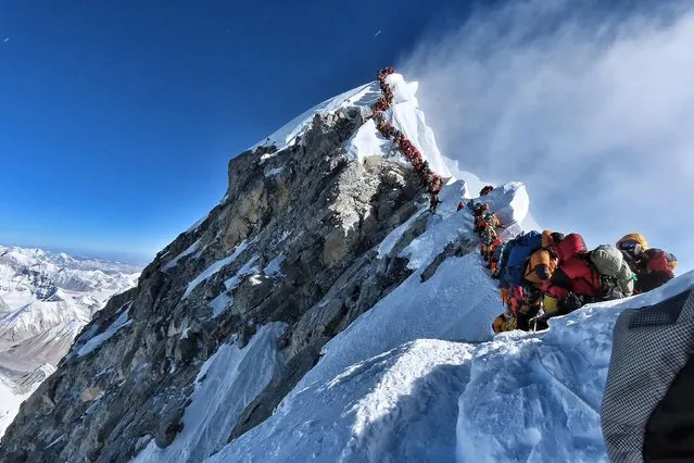 In this file handout photo taken on May 22, 2019 and released by climber Nirmal Purja's Project Possible expedition shows heavy traffic of mountain climbers lining up to stand at the summit of Mount Everest. Three more climbers have died on Everest, expedition organisers and officials said on May 24, taking the toll from a deadly week on the overcrowded world's highest peak to seven. (Photo by Handout/Project Possible/AFP Photo)