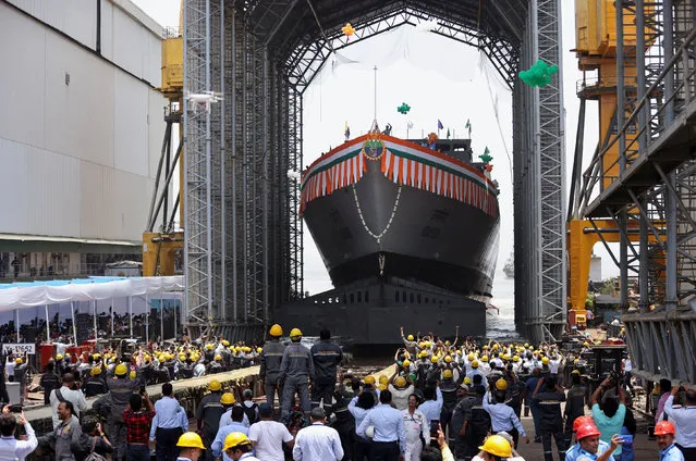 Workers wave during the launch of the second advanced stealth frigate warship under Project 17A named Udaygiri at the Mazagon Dock Shipbuilders Limited (MDL), in Mumbai, India, May 17, 2022. (Photo by Francis Mascarenhas/Reuters)