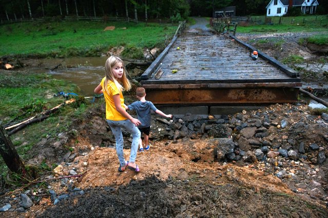  Kids play   on the remainder of a washed-out road to their home in Watauga County on September 27, 2024. Heavy rains brought uncharacteristic flooding to many parts of the North Carolina mountains. Rains from what was Hurricane Helene have dropped more than a foot of rain across much of the region.  (Photo by Melissa Sue Gerrits/Getty Images)es)