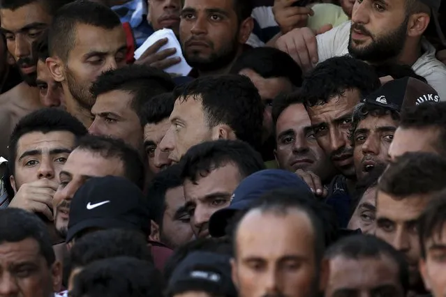 Migrants and refugees stand in a crowded line during a registration procedure at the national stadium of the Greek island of Kos, August 12, 2015. (Photo by Alkis Konstantinidis/Reuters)