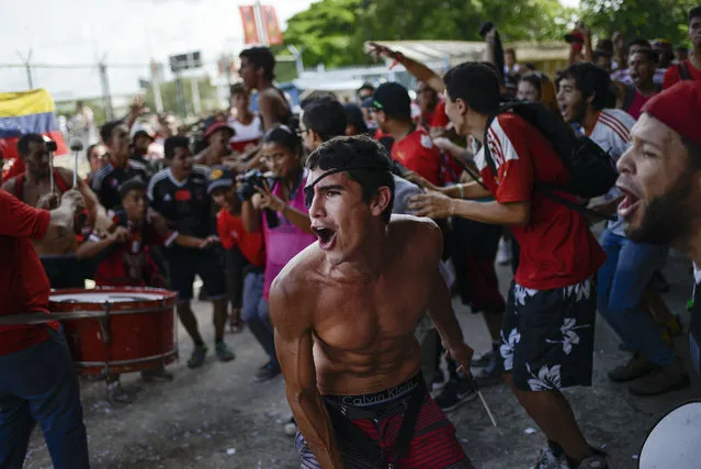 In this July 10, 2019 photo, David Osorio, member of the Caracas FC fan club, sings and plays a drum before a Copa Sudamerica soccer match between his team and Ecuador's Independiente del Valle at Estadio Olímpico in Caracas, Venezuela. When the Caracas Football Club plays, its supporters leave their ideological preferences and socioeconomic differences behind, joining together to support and take care of each other inside and outside the stadium. (Photo by Matias Delacroix/AP Photo)
