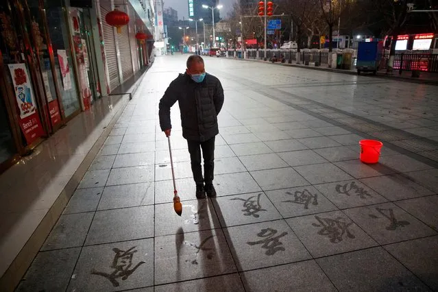 A man wears a face mask as he practices calligraphy on the pavement in Jiujiang, Jiangxi province, China, February 3, 2020. (Photo by Thomas Peter/Reuters)