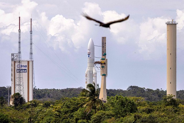 This photograph taken on July 3, 2023, shows the assembled Ariane 5 rocket (C) arriving on the launch pad of Europe's Spaceport, the Guiana Space Center in Kourou, French Guiana. This will be the last launch of an Ariane 5 rocket. Initially scheduled for June 16, 2023, this launch has been postponed following anomalies detected during inspections. (Photo by Jody Amiet/AFP Photo)