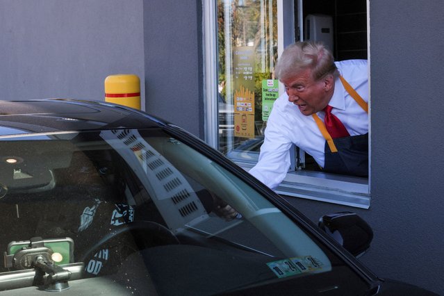 Donald Trump serves food at a McDonalds restaurant in Feasterville-Trevose, Pennsylvania on October 20, 2024. (Photo by Brian Snyder/Reuters)