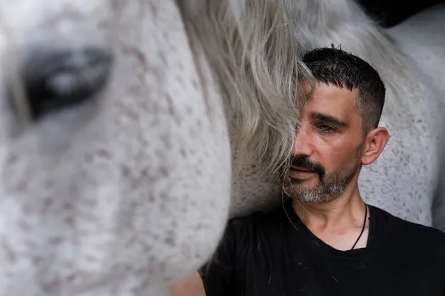 Turkey's first Paralympic horse rider Tolga Dokuyucu stands next to horse Balfi after training at the Equestrian Sports Club in Ankara, Turkey, 14 June 2022. Dokuyucu started horse riding at the age of seven and later joined the apprentice jockey school. At the age of 30 he was seriously injured as a result of falling off the horse during the Ankara 75th Year Racecourse, when he lost his sight due to head trauma and broke his leg. After three expensive medical treatments, Dokuyucu started working in the streets of Ankara, selling lighters, wet wipes and pens at subway exits. He did eventually return to horse riding, becoming a member of the Equestrian Sports Club. Married and father of two, Dokuyucu is currently training to compete in the France 2024 Summer Paralympics in the Dressage category as Turkey's first Paralympic horse rider. During an interview with epa, he said: “After the accident, I thought I would not be able to ride a horse again. Now I am preparing for the Paralympic Games. My goal is to return home with a medal. Horses are a light for me”. (Photo by Sedat Suna/EPA/EFE)