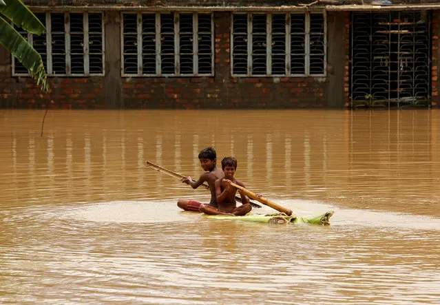 Boys row a makeshift raft at a flooded village in Howrah district, West Bengal, India August 2, 2017. (Photo by Rupak De Chowdhuri/Reuters)