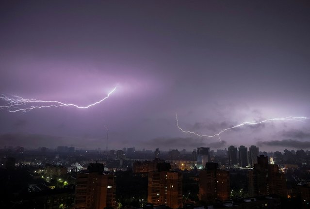 A flash from the lightning illuminates the sky over the city during an air raid alert, amid Russia's attack on Ukraine, in Kyiv, Ukraine on June 12, 2024. (Photo by Gleb Garanich/Reuters)