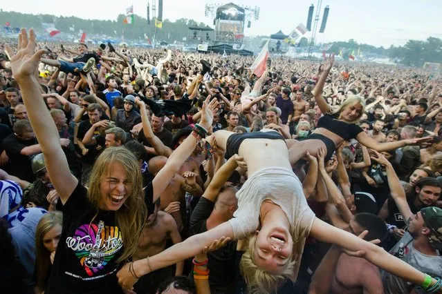 A woman crowd-surfs in front of the main stage at the Woodstock Festival in Kostrzyn-upon-Odra, close to the Polish-German border, August 2, 2014. Some 500 thousand people attended the festival that is the brainchild of Polish journalist and social campaigner Jerzy Owsiak. He initiated the event to say thank you to those who donated money to his GOCC charity organisation that delivers medical care for children. (Photo by Thomas Peter/Reuters)