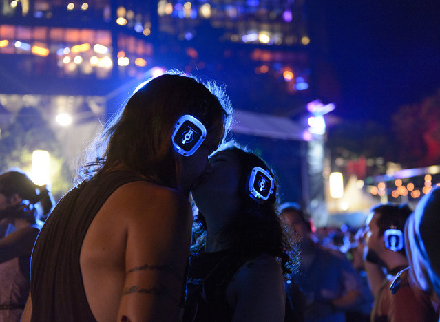 Festival goers kiss in the “Silent Disco” at the “Music in the Park” stage during the 50th Montreux Jazz Festival, in Montreux, Switzerland, July 9, 2016. (Photo by Anthony Anex/EPA)