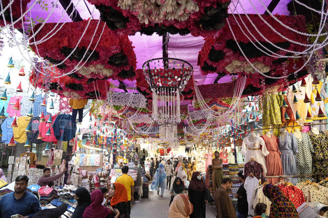 People walk through a market decorated for the upcoming Mawlid al-Nabi holiday celebrating the birthday of Islam's Prophet Muhammad in Lahore, Pakistan, Monday, September 16, 2024. (Photo by K.M. Chaudary/AP Photo)