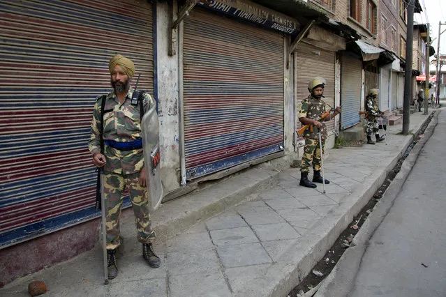 Indian paramilitary soldiers stand guard outside a closed market during the eleventh straight day of curfew in Srinagar, Indian controlled Kashmir, Tuesday, July 19, 2016. (Photo by Dar Yasin/AP Photo)