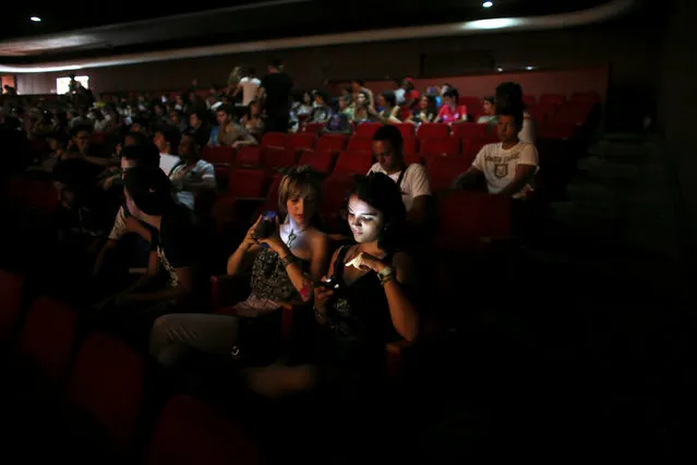 People use cell phones and tablets at a cinema where the Cuban Otaku festival is taking place in Havana, Cuba, July 24, 2016. (Photo by Alexandre Meneghini/Reuters)