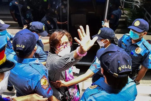 Former Philippine Senator and human rights campaigner Leila de Lima, a high-profile critic of former president Rodrigo Duterte and his deadly drug war, is escorted by police as she emerges from her hearing at the Muntinlupa Trial Court in Manila on August 26, 2022. (Photo by Maria Salvador Tan/AFP Photo)