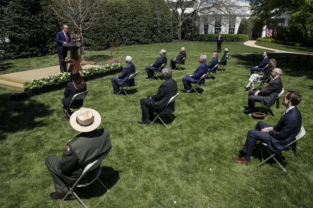 Members of the audience sit at socially-distant intervals due to the coronavirus disease (COVID-19) outbreak as U.S. President Donald Trump and first lady Melania Trump hold a tree-planting ceremony outside the Oval Office on the 50th anniversary of Earth Day at the White House in Washington, U.S. April 22, 2020. (Photo by Jonathan Ernst/Reuters)