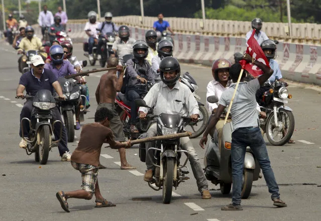 Activists of a trade union group stop motorcyclists to keep vehicles off the road during a daylong nationwide strike in the eastern Indian city Bhubaneswar, India, Wednesday, September 2, 2015. Normal life was affected in several parts of the state following a day-long nationwide general strike called by ten central trade unions to protest changes in labour laws and privatisation of Public Sector Undertaking's (PSU) by the ruling Bharatiya Janata Party (BJP) government. (Photo by Biswaranjan Rout/AP Photo)