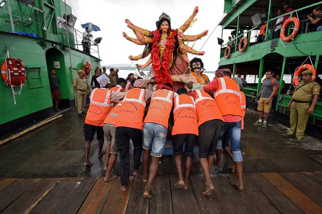 Municipal workers carry an idol of the Hindu goddess Durga for immersion in the waters of the river Brahmaputra on the last day of the Durga Puja festival in Guwahati, September 30, 2017. (Photo by Anuwar Hazarika/Reuters)