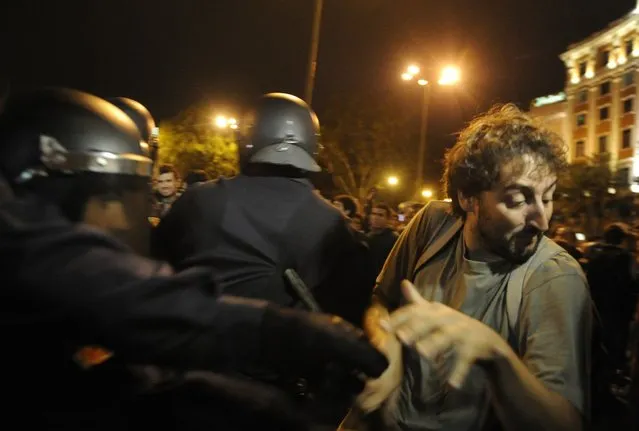 A protester clashes with riot policemen during a demonstration organized by Spain's "indignant" protesters to decry an economic crisis they say has "kidnapped" democracy, on September 25, 2012 in Madrid. Spanish riot police fired rubber bullets and baton-charged protesters as thousands rallied near parliament in Madrid in anger at the government's handling of the economic crisis.  AFP PHOTO / DOMINIQUE FAGET        (Photo credit should read DOMINIQUE FAGET/AFP/GettyImages)