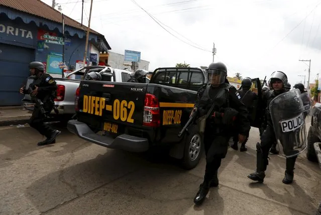 Riot police officers walk during a protest against the re-election of the city's mayor Rubelio Recinos of the Patriot Party in Barberena, northwest of Guatemala City, September 8, 2015. The demonstrators were protesting against what they say were irregularities in the margin of votes in which Recinos won by 169, according to local media. (Photo by Jorge Dan Lopez/Reuters)