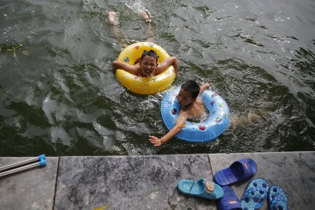 Children swim in Houhai lake during hot weather in Beijing, China, 10 August 2016. Local residents enjoy swimming in the lake to cool down during continuous high temperatures. (Photo by Wu Hong/EPA)