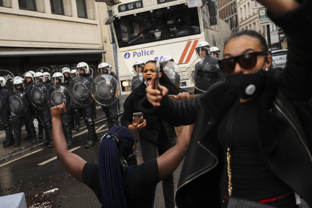 Protesters call to calm down rioters during clashes between police and small groups of rioters after a Black Lives Matter protest rally in Brussels, Sunday, June 7, 2020. Just like the coronavirus, racism has no borders. Across the world, disgruntled people, representing a broad spectrum of society, marched this weekend as one to protest against racial injustices at home and abroad. (Photo by Francisco Seco/AP Photo)