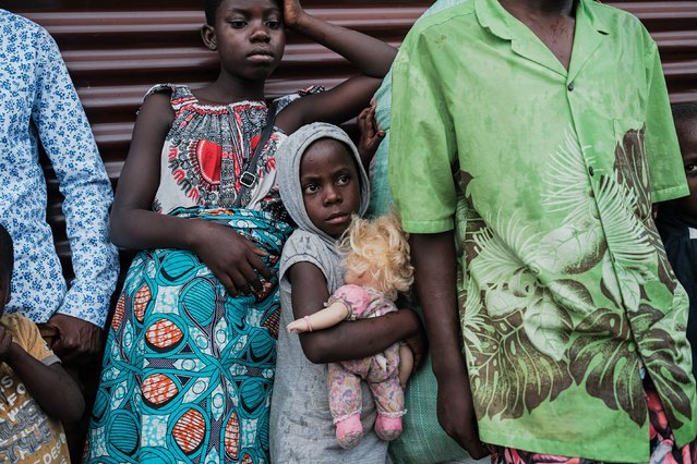 A girl carries her doll along with her family as Congolese refugees displaced by ongoing clashes in eastern Democratic Republic of Congo upon arrival at the Rugombo refugee camp in Rugombo on February 17, 2025. (Photo by Tchandrou Nitanga/AFP Photo)