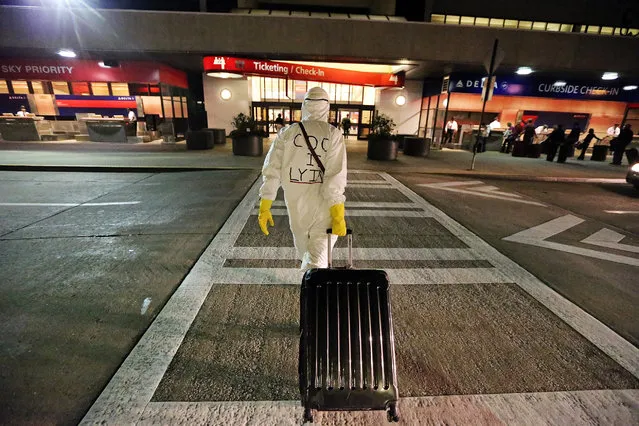 Two days after a man in Texas was diagnosed with Ebola, Dr. Gil Mobley, a Missouri doctor, walks to Hartsfield-Jackson Atlanta International Airport to check in and board a plane dressed in full protection gear Thursday morning, October 2, 2014, in Atlantat. He was protesting what he called mismanagement of the crisis by the federal Centers for Disease Control and Prevention. (Photo by John Spink/AP Photo/Atlanta Journal-Constitution)