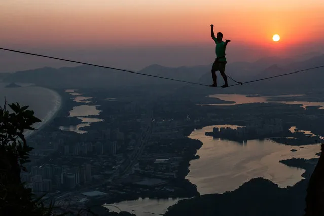 Brave slackliners have been pictured walking the ropes above Rio de Janeiro, Brazil on August 15, 2016, with the half a mile drop showing the city in all its glory. The stunning shots show the daredevils tread across an eighty-two-foot-long high line on Pedra da Gvea mountain with an amazing sunrise illuminating the city landscape behind. (Photo by Rafael Moura/Caters News Agency)