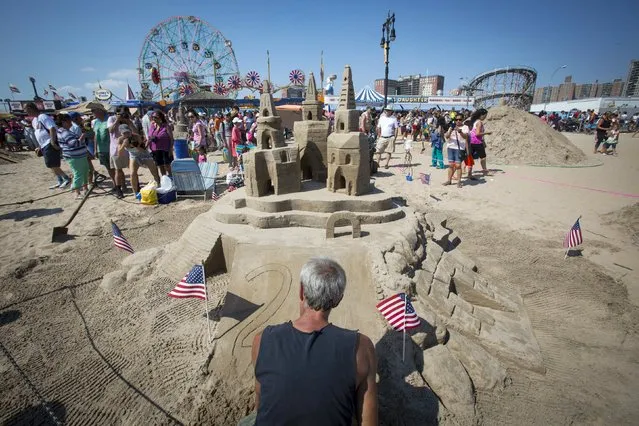 Rich Demand of Sea Cliff, Long Island works on his creation titled “Three Times a Charm” during the Coney Island Sand Sculpting Contest at Coney Island in Brooklyn, New York August 15, 2015. The contest, running for its 25th year, features competitors from around the country and offers cash prizes to the winner. (Photo by Andrew Kelly/Reuters)