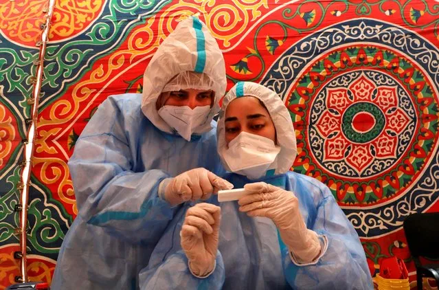 Doctors, from the Palestinian Ministry of Health, take blood samples from a person suspected of being infected with the novel coronavirus COVID-19 in Hebron in the occupied West Bank on July 15, 2020. (Photo by Hazem Bader/AFP Photo)