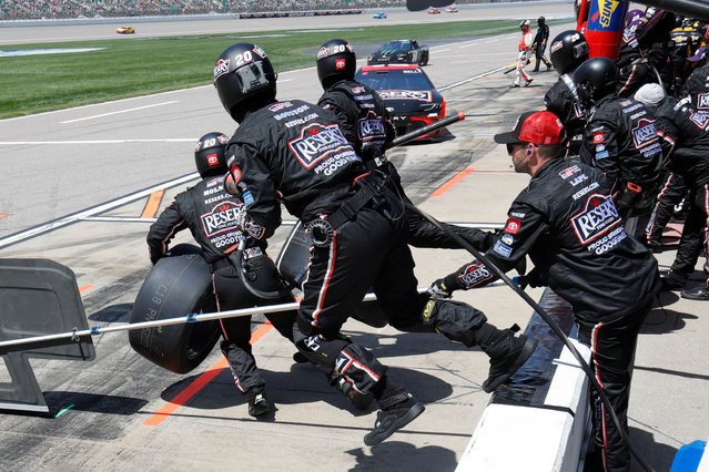 Christopher Bell's pit crew jumps the safety wall as he comes in for a tire change during a NASCAR Cup Series auto race at Kansas Speedway in Kansas City, Kan., Sunday, May 11, 2025. (Photo by Colin E. Braley/AP Photo)