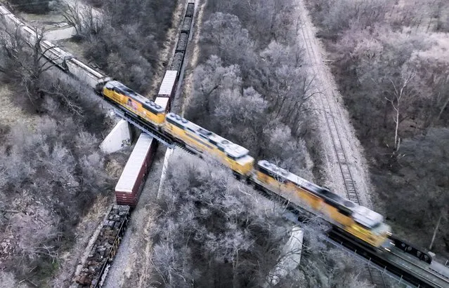 An aerial photo made with a drone shows a freight train passing over parked rail cars in Janesville, Wisconsin, USA, 02 December 2022. US President Joe Biden signed legislation to prevent a nationwide strike by railroad workers that officials claim would have crippled the US economy. (Photo by Tannen Maury/EPA/EFE)