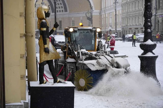 A snow removal machine drives during snowfall in St. Petersburg, Russia on Tuesday, December 6, 2022. (Photo by Dmitri Lovetsky/AP Photo)