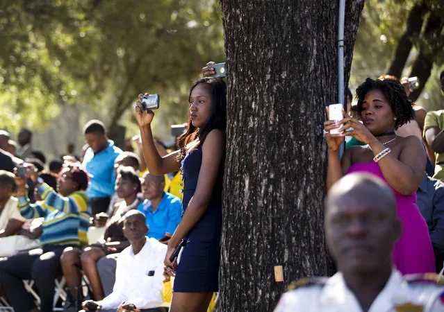 Relatives and friends take pictures of national police officers during their graduation ceremony in Port-au-Prince, Haiti, on December 18, 2017. (Photo by Dieu Nalio Chery/AP Photo)