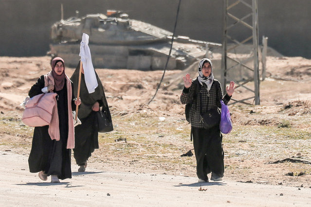 Displaced Palestinian women carrying their belongings lift a makeshift white flag as they walk past Israeli forces while fleeing the Hamad City area in Khan Yunis in the southern Gaza Strip on March 5, 2024, amid the ongoing conflict between Israel and the Hamas movement. (Photo by AFP Photo/Stringer)