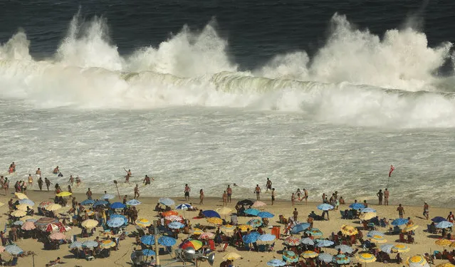 Waves break as people gather on Copacabana beach on January 28, 2018 in Rio de Janeiro, Brazil. According to researchers from the Chinese Academy of Sciences, 2017 was the warmest year recorded in Earth's oceans. Researchers noted a “long-term warming trend driven by human activities”. (Photo by Mario Tama/Getty Images)