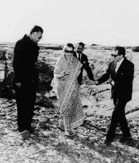 In this December 22, 1974, file photo, Indian Prime Minister Indira Gandhi, center, examines a piece of rock at the nuclear test site in Pokhran, southeastern India. Gandhi is flanked at left by K.C. Pant, Indian minister of energy and Dr. H.C. Sethna, right, then chairman of the Atomic Energy Commission. In May 1974, India conducted a nuclear test in the Rajasthani desert, the first nation to do so outside the permanent U.N. Security Council. (Photo by AP Photo)