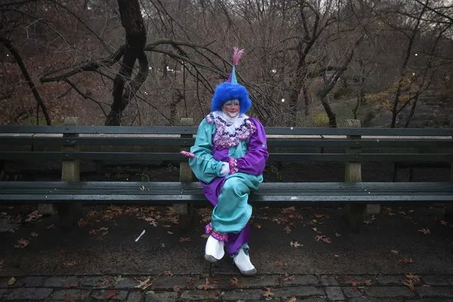 A clown sits on a park bench at sunrise before the Macy's Thanksgiving Day Parade in New York, November 27, 2014. (Photo by Carlo Allegri/Reuters)