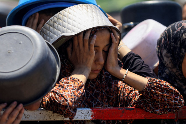 A Palestinian girl reacts as she waits to receive food from a charity kitchen, amid a hunger crisis, in Gaza City on July 22, 2025. (Photo by Dawoud Abu Alkas/Reuters)