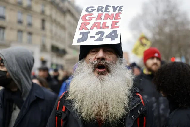 A protester holds a placard reading: “General Strike J-24” during a demonstration against plans to push back France's retirement age, in Paris, Saturday, February 11, 2023. France is bracing itself for a fourth round of nationwide protests against President Emmanuel Macron's plans to reform pensions but key transports unions have not called for strikes allowing trains and the Paris metro to run this time. (Photo by Lewis Joly/AP Photo)