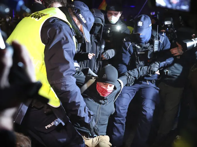 Police remove from the street outside the Education Ministry protesters who demand the firing of the new minister in the right-wing government, who has made a number of unpopular statements, in Warsaw, Poland, Monday, November 9, 2020. (Photo by Czarek Sokolowski/AP Photo)