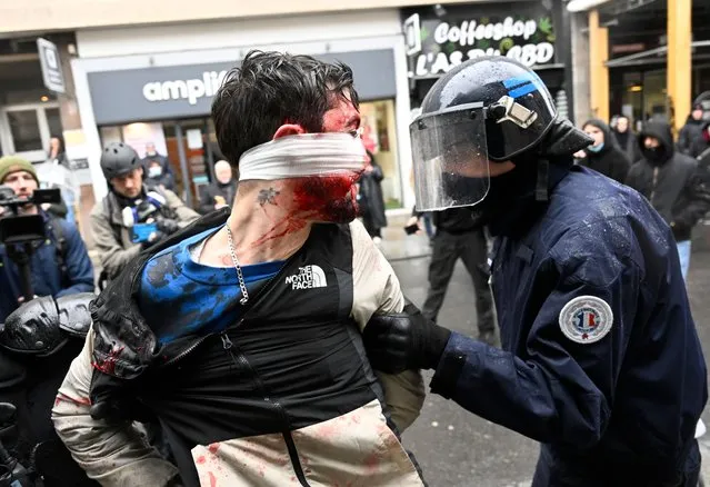 Riot police officers detain a person during a rally organised by fishermen against the “regulations and persecution of the Management of Maritime Affairs (direction des affaires maritimes)”, in Rennes, western France, on March 22, 2023. (Photo by Damien Meyer/AFP Photo)