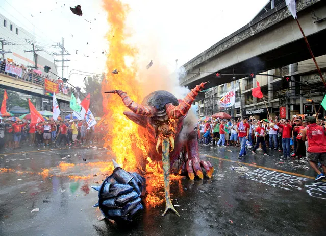 Protesters watch the burning of an effigy of President Rodrigo Duterte during a May Day rally, outside the Malacanang Presidential Palace in Mendiola, Metro Manila, Philippines on May 1, 2018. (Photo by Romeo Ranoco/Reuters)