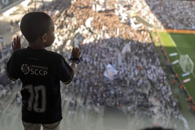 Five-years-old Arthur Alves, with autism spectrum disorder, watches a Brazilian championship match between Corinthians and Cruzeiro in a special isolated room where noise impacts less, at the Neo Quimica Arena in Sao Paulo, Brazil, Sunday, April 16, 2023. Brazilian soccer clubs are increasingly opening spaces for autistic fans to watch matches, mingle and celebrate the sport, an initiative that got even higher attention in April, when Autism Speaks celebrates World Autism Awareness Month. (Photo by Andre Penner/AP Photo)