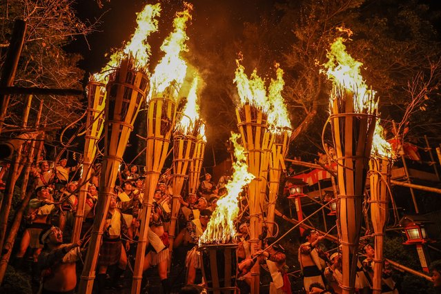 Participants carry large torches during the Kurama Fire Festival on October 22, 2025 in Kyoto, Japan. (Photo by The Asahi Shimbun via Getty Images)