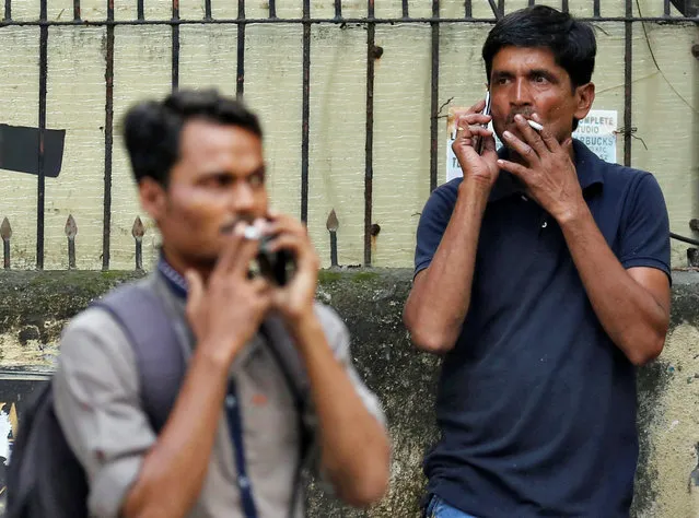 People smoke cigarettes along a road in Mumbai, India, October 26, 2016. (Photo by Danish Siddiqui/Reuters)