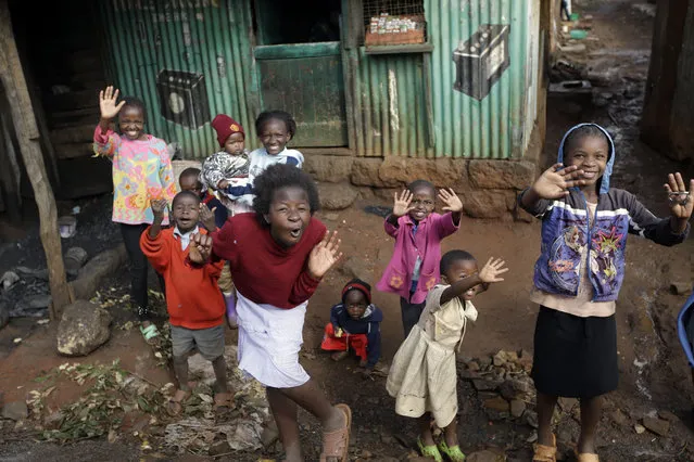 Children cheer and wave during Pope Francis' visit to the Kangemi slum, in Nairobi, Kenya, Friday, November 27, 2015. Pope Francis denounced the conditions slum-dwellers are forced to live in during a visit to one of Nairobi's many shantytowns Friday, saying that access to safe water is a basic human right and that everyone should have dignified, adequate housing. (Photo by Andrew Medichini/AP Photo)