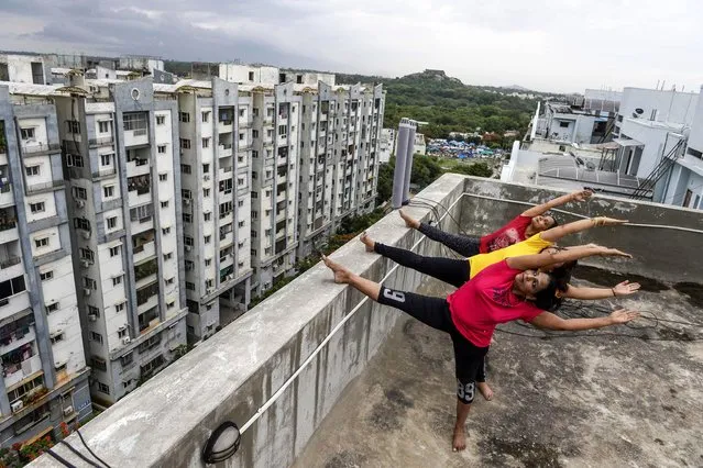 Yoga instructors from Anahata Yoga Zone perform yoga postures on a building's terrace in Hyderabad on June 18, 2020, ahead of the International Yoga Day annually celebrated on June 21. (Photo by Noah Seelam/AFP Photo)
