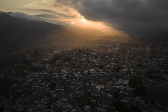 The sun rises over homes covering a hill in the Catia neighborhood of Caracas, Venezuela, Thursday, March 30, 2023. (Photo by Matias Delacroix/AP Photo)